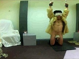 Gay slave suspended in fur coat for pleasure