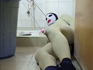 Zentai femdom commands submissive slave in toilet bondage